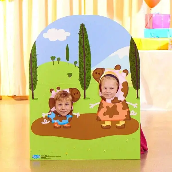 Farm-themed party photo board with cartoon cow characters and face cut-outs set against a countryside background.